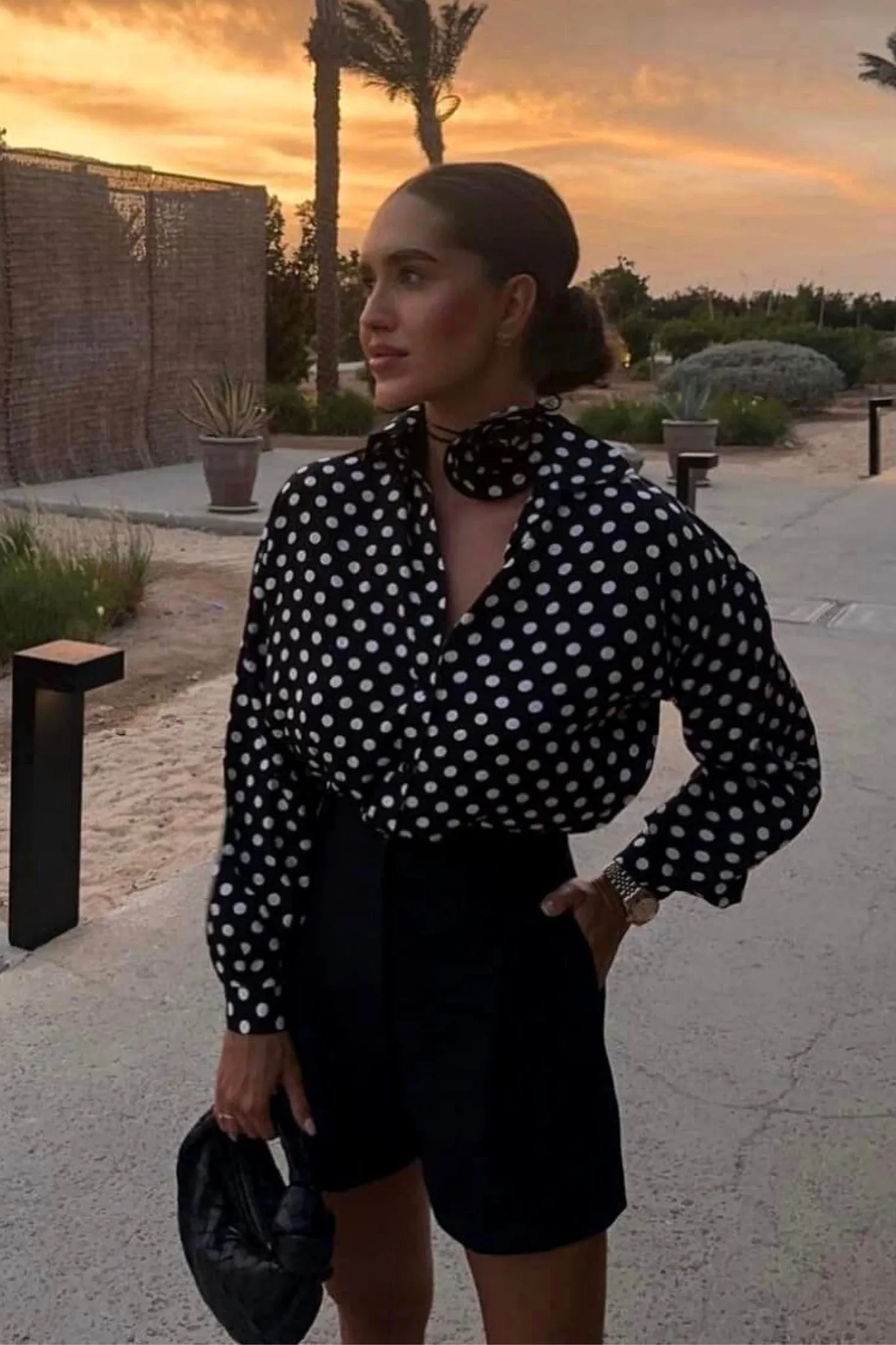 Camicia nera a stampa pois bianchi in viscosa accessoriata con fiore in tessuto