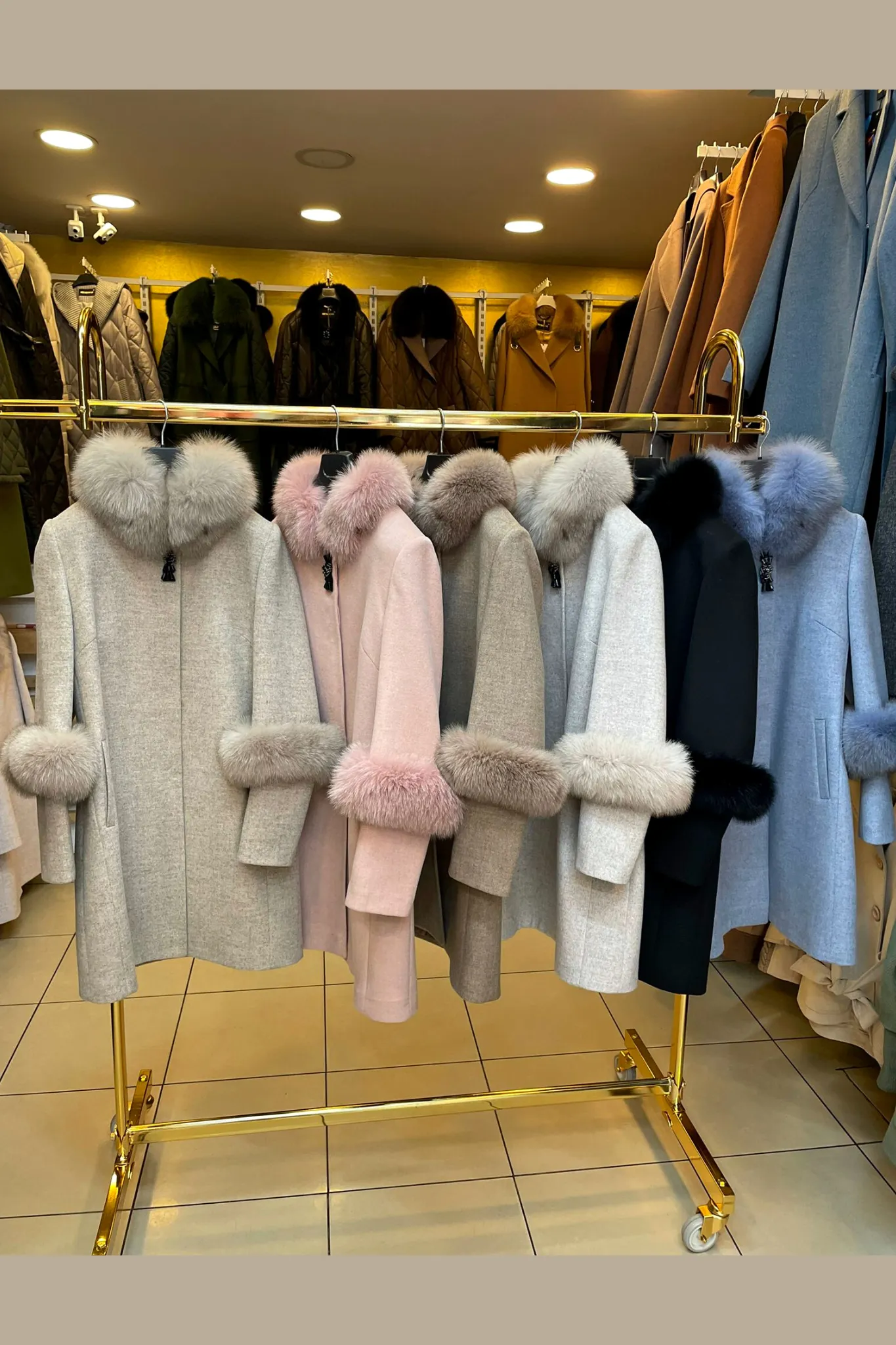 Cappotto rosa invernale a collo alto accessoriato con spilla decorativa e pelo naturale