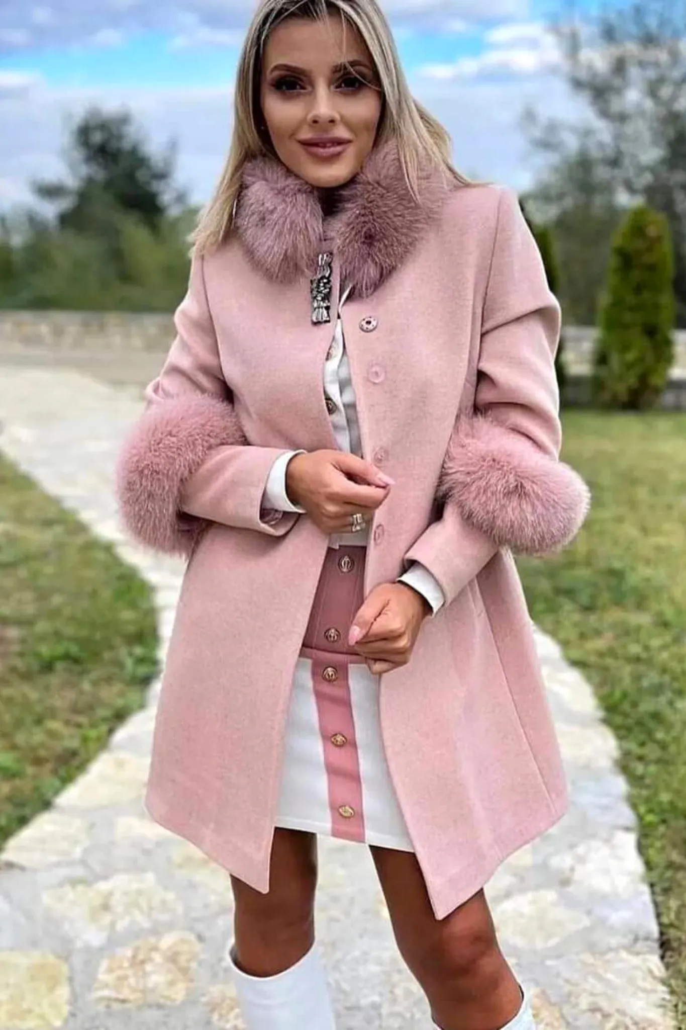 Cappotto rosa invernale a collo alto accessoriato con spilla decorativa e pelo naturale